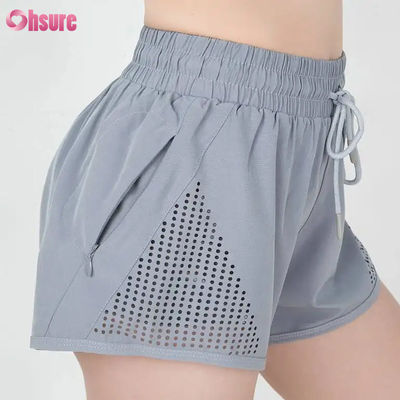 Shorts de sport d'entraînement pour femmes en gros, respirants, avec découpe laser, shorts de jogging avec poche latérale zippée d'échauffement, motif uni