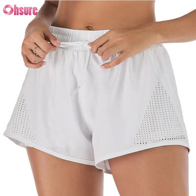 Shorts de sport d'entraînement pour femmes en gros, respirants, avec découpe laser, shorts de jogging avec poche latérale zippée d'échauffement, motif uni